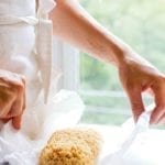 A woman holding a small batch of Rice Krispies treats for two on a piece of wax paper.