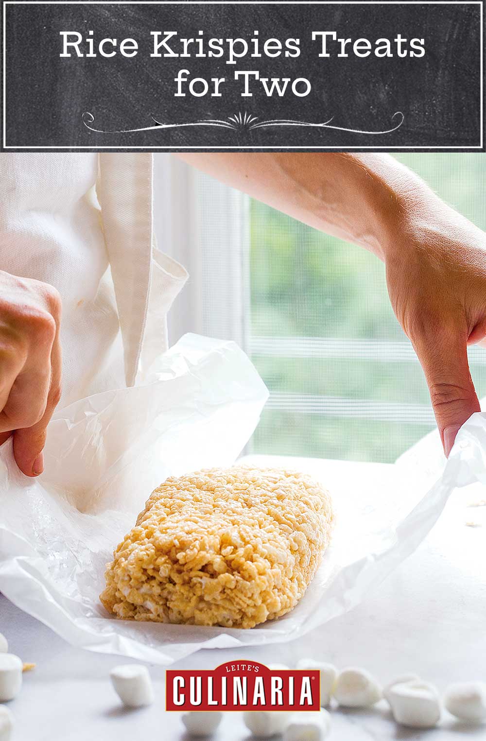 A woman holding a small batch of Rice Krispies treats for two on a piece of wax paper.