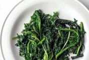 A pile of charred greens--kale and spinach--on a white plate