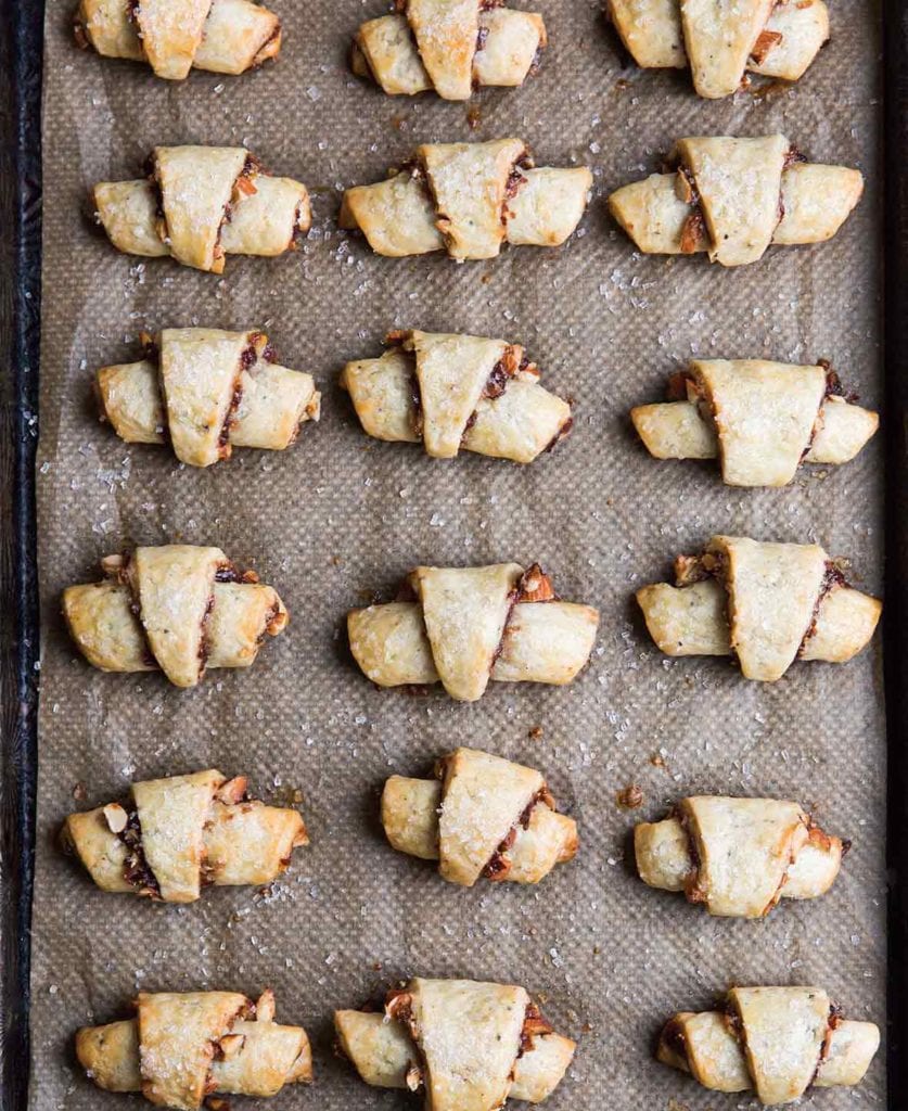 A baking sheet with four rows of baked fig rugelach, worthy of a cookie swap