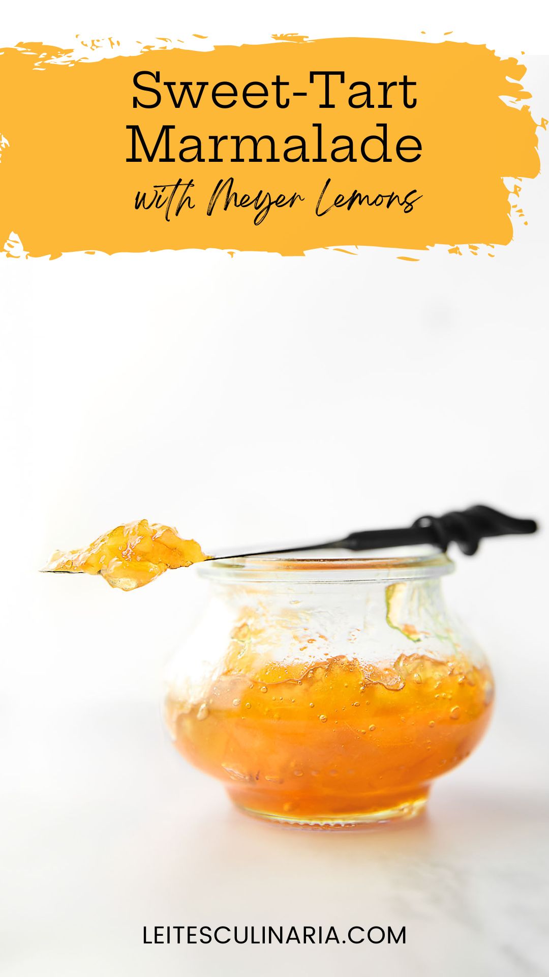 A small jam jar filled with Meyer lemon marmalade. Resting on top is a knife with a dollop of marmalade on top.