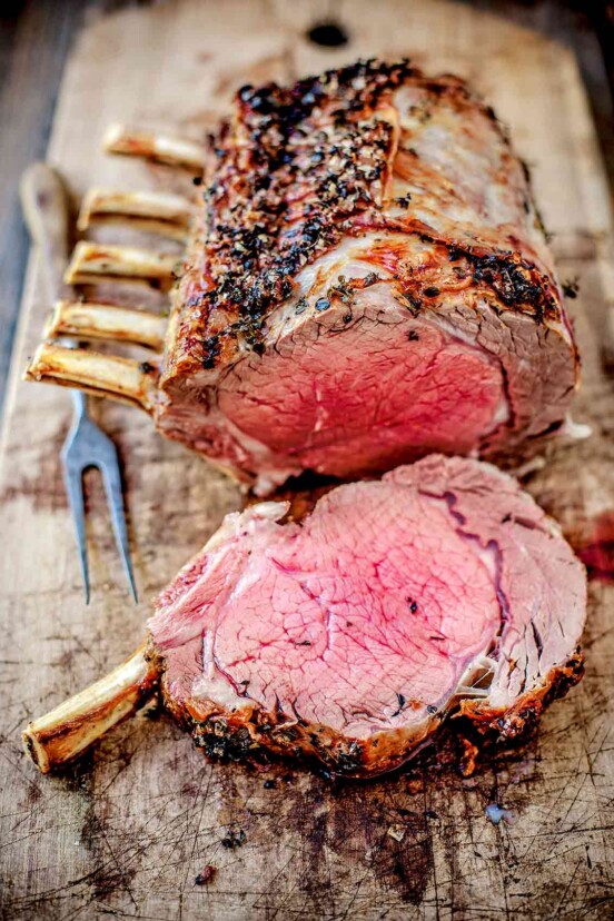 Medium-rare sliced standing rib roast on a cutting board