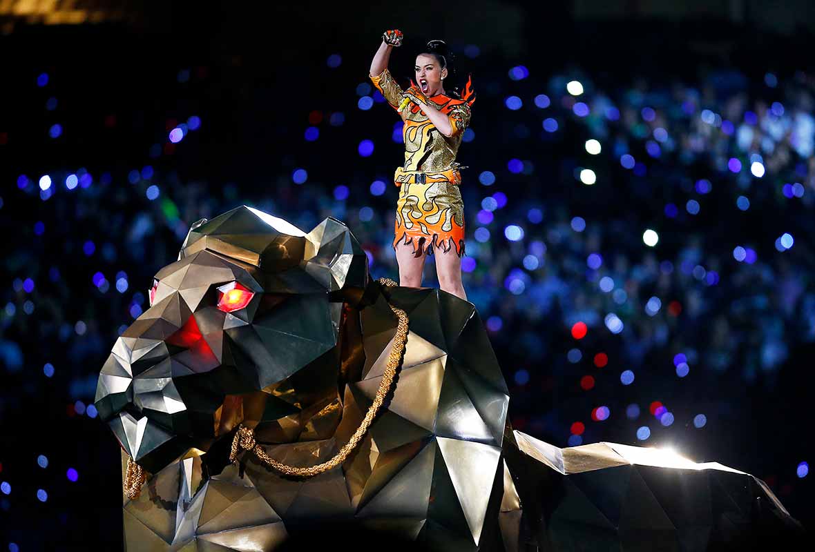 Katy Perry singing on top of a huge golden tiger puppet