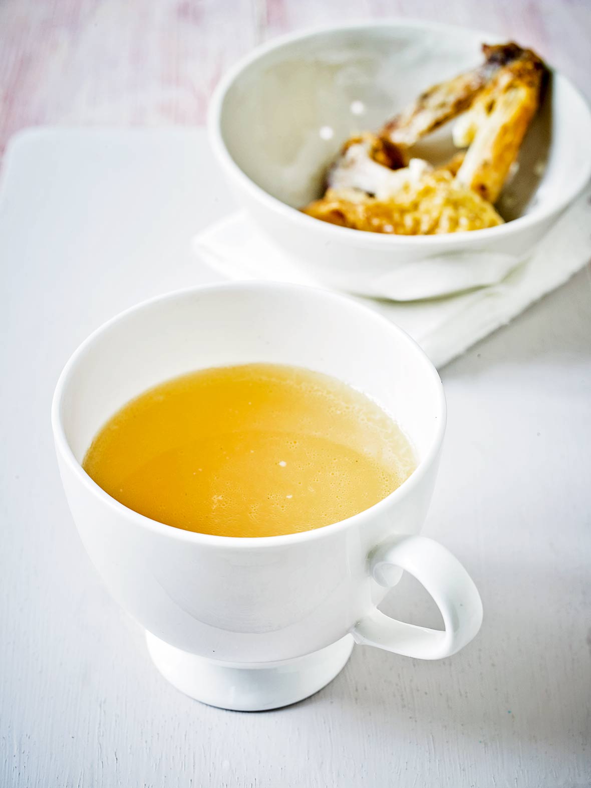 A white mug of chicken stock