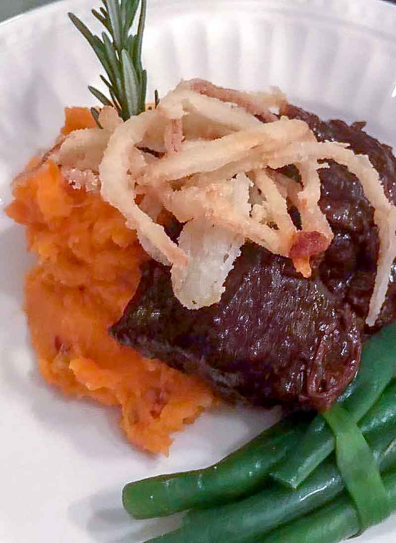 Braised short ribs over whipped sweet potatoes, green beans, and fried onion rings