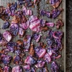 Roasted red cabbage on a cooling rack set in a baking sheet.