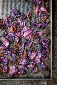 Roasted red cabbage on a cooling rack set in a baking sheet.