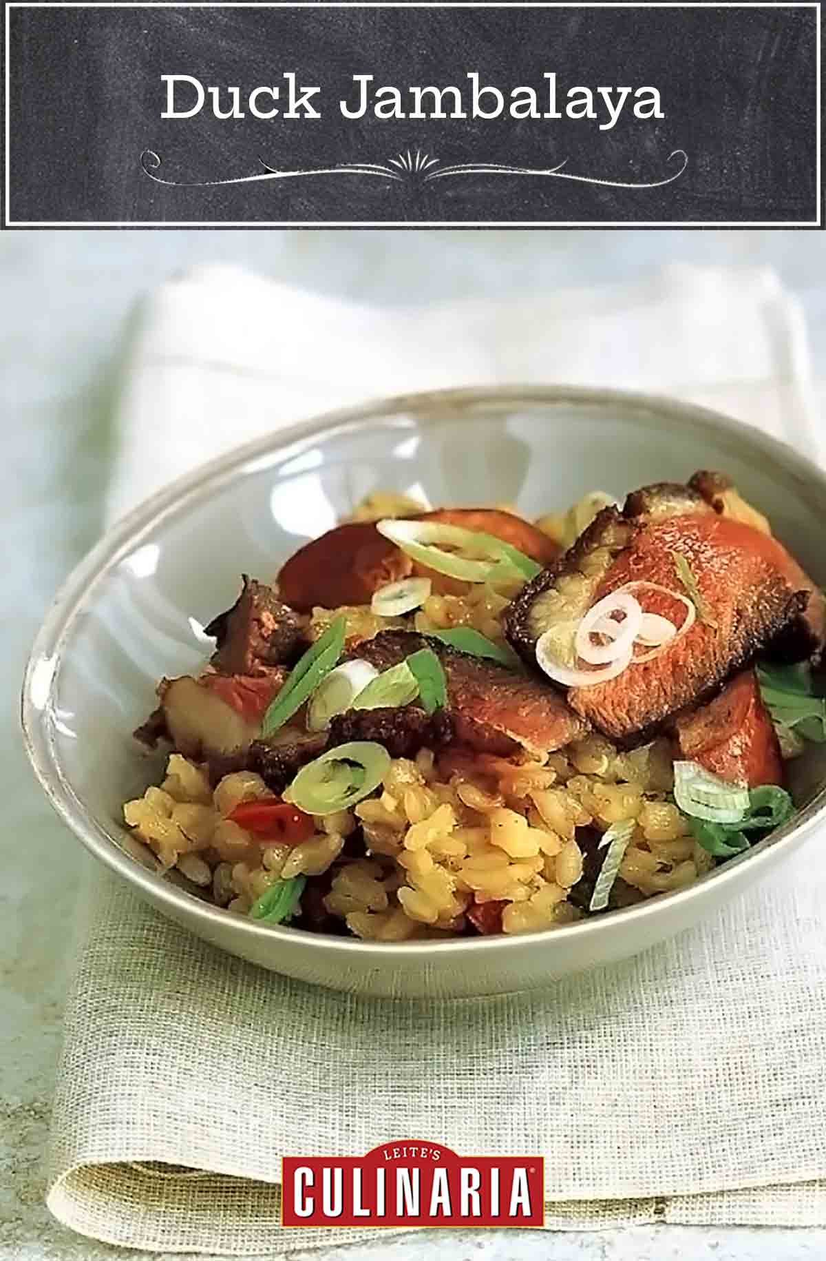 A bowl filled with duck jambalaya and topped with sausage