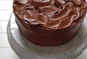 A Hershey chocolate cake with swirled chocolate frosting on a white cake stand