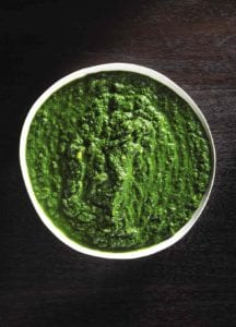 Bowl of Indian creamed spinach on black wood