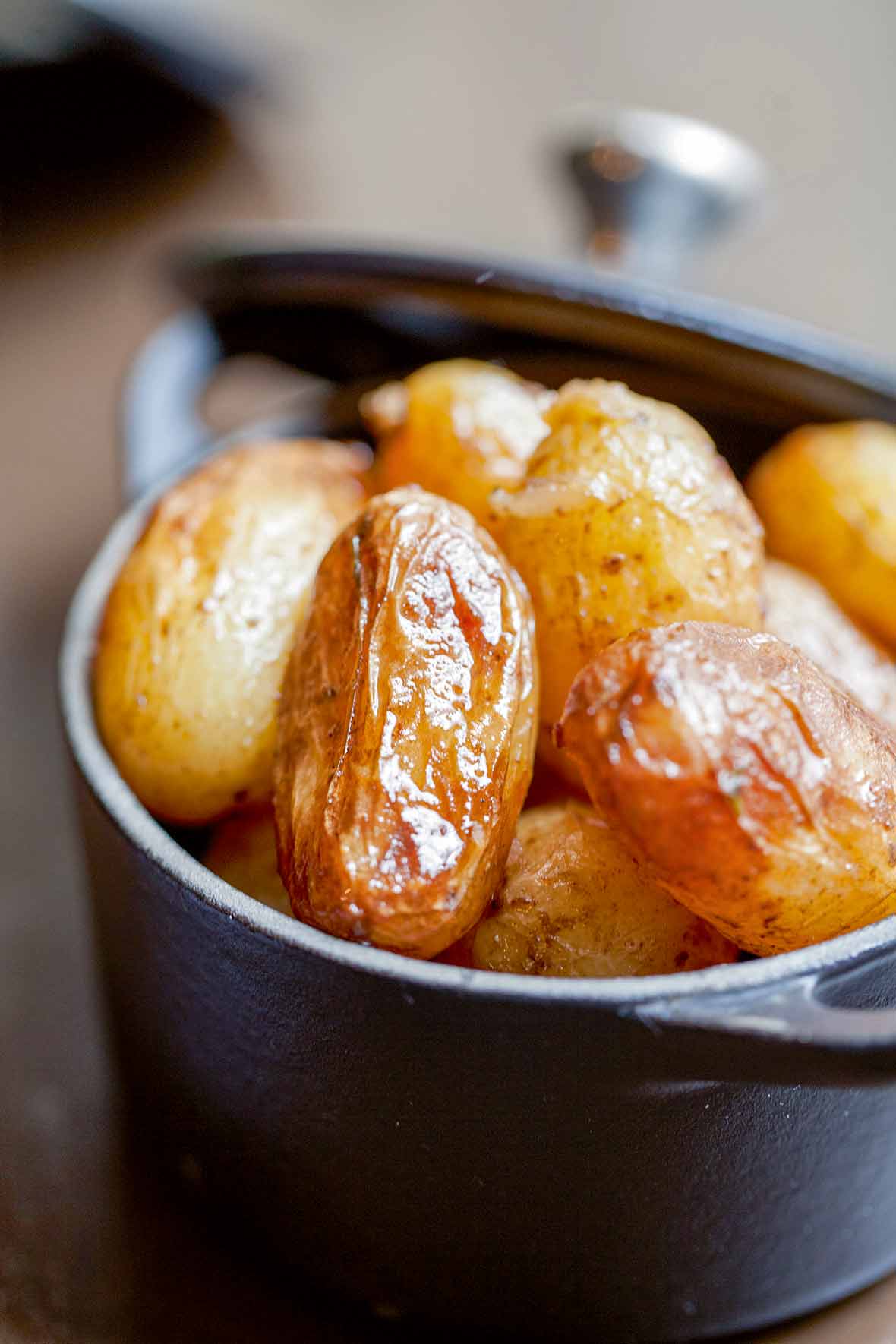 Cast iron pot with braised new potatoes inside.