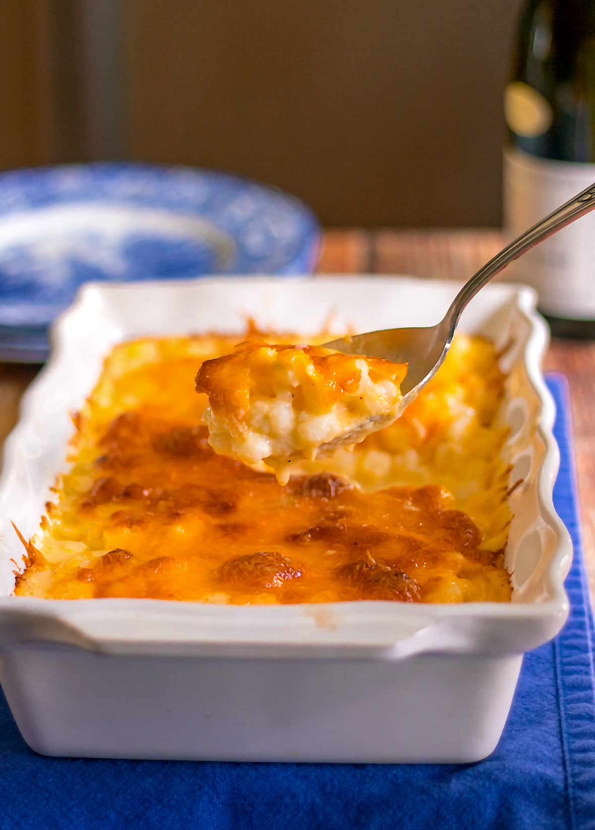 A casserole dish of hominy au gratin--hominy in a cheese sauce--plus a spoon filled with the cheesy hominy