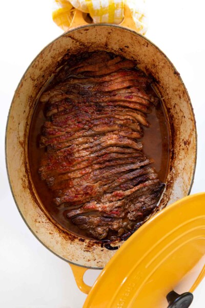 A yellow Le Creuset pot with Nach Waxman's sliced beef brisket inside