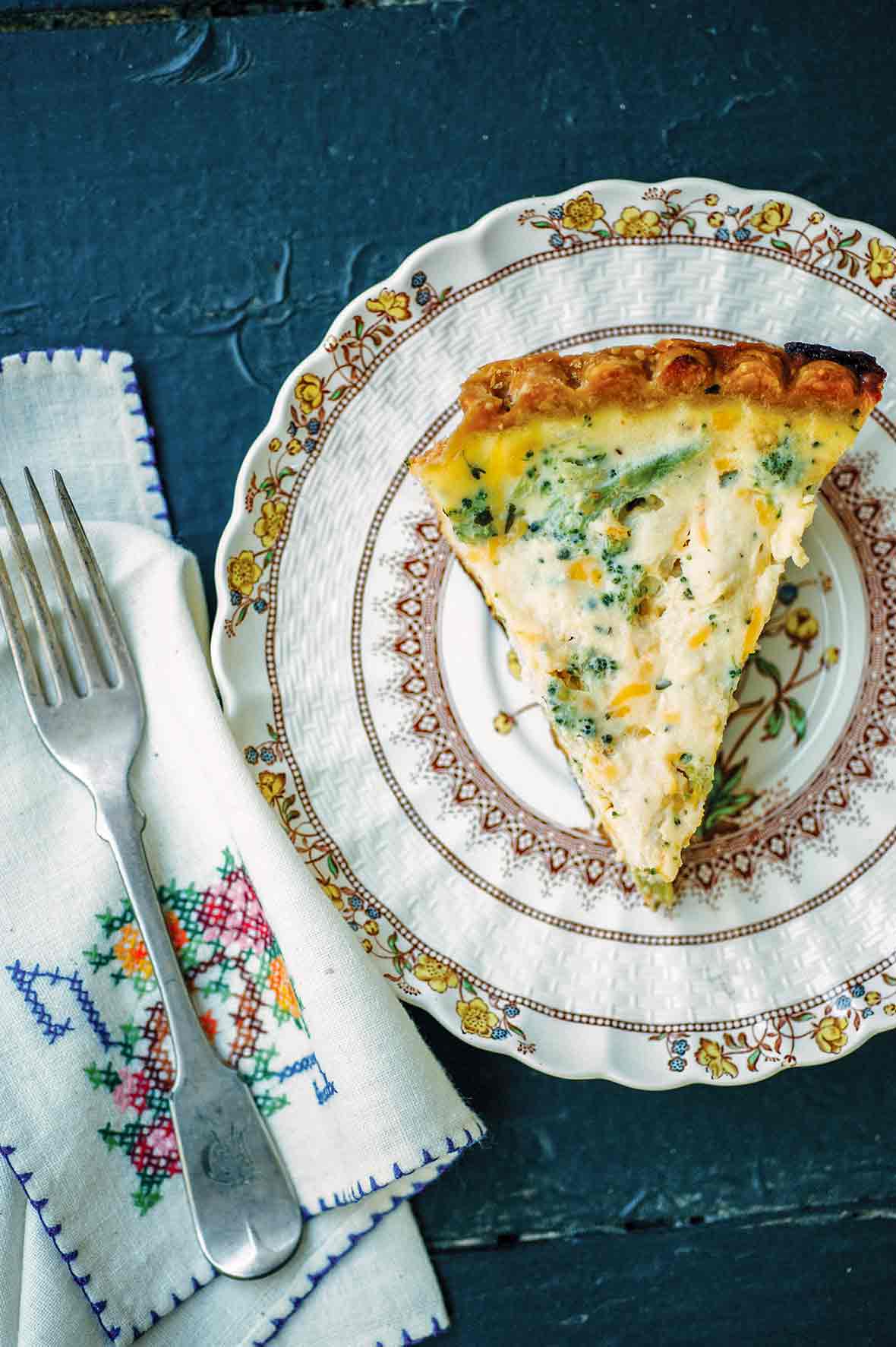 A plate with a slice of broccoli Cheddar quiche.