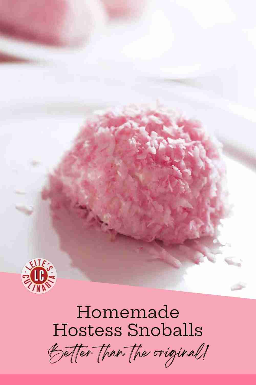 Domed chocolate cakes frosted with fluffy pink meringue and coated in bright pink shredded coconut resting on white dessert plates.