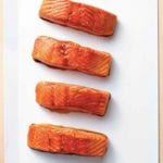 Four fillets of maple glazed salmon of a white square platter