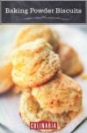Baking powder biscuits piled on a white square plate.