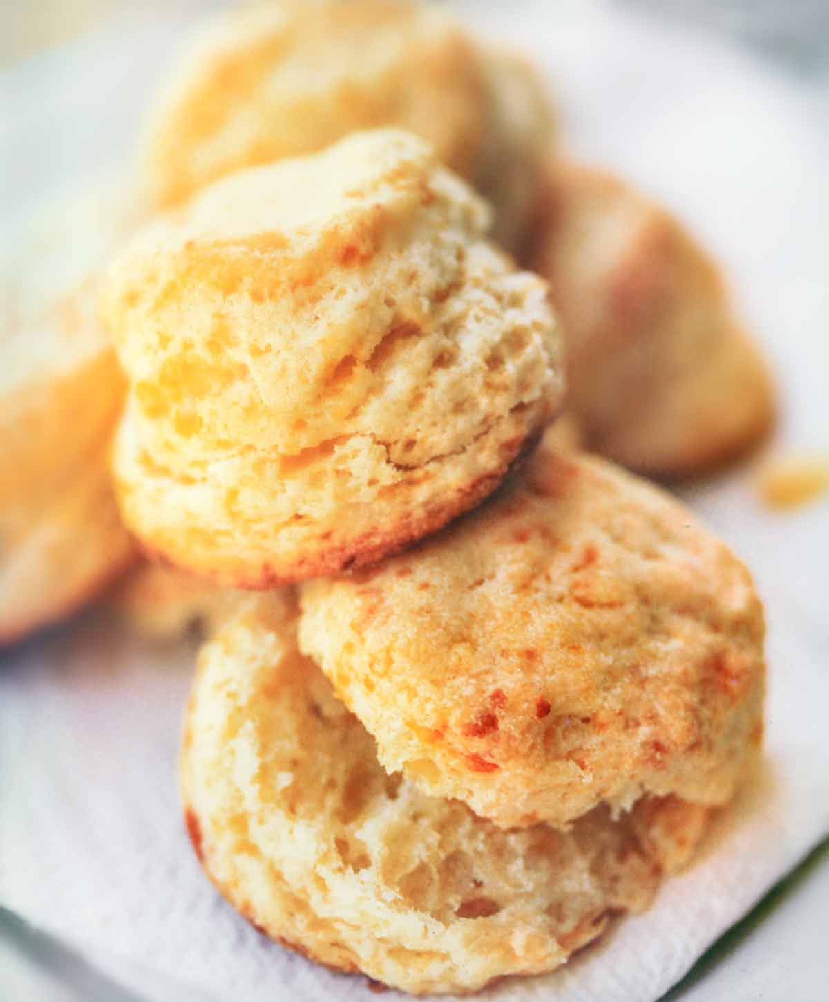 Baking powder biscuits piled on a white square plate.