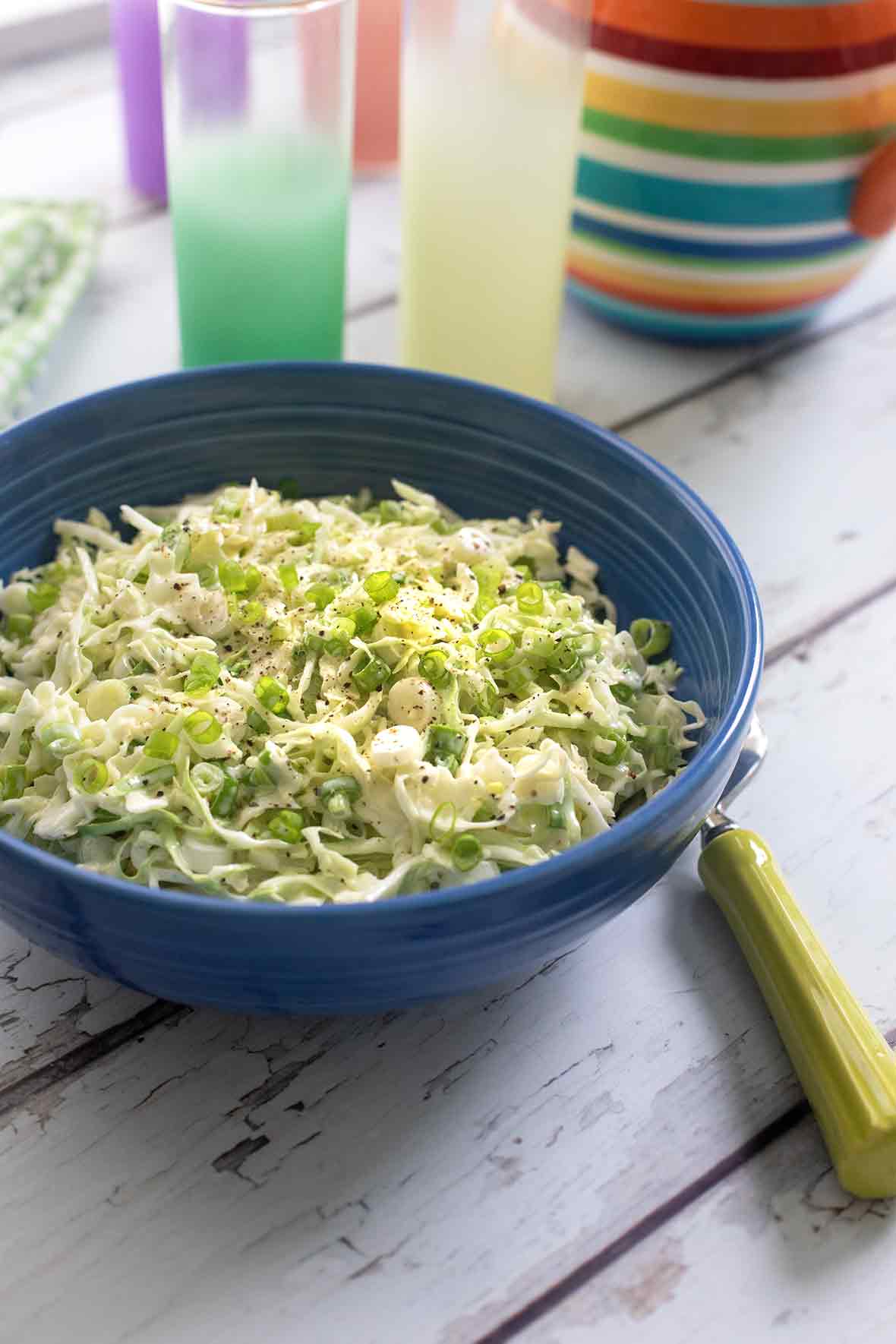 A blue ceramic bowl filled with classic coleslaw.