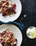 Two white plate of farro salad with radicchio and almonds, bowl of lemons, napkin