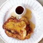 Three slices of French toast drizzled with Earl Grey syrup on a white plate.