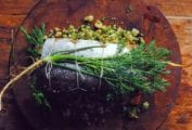 A whole herb stuffed baked salmon filled with bread crumbs and herbs and tied with kitchen twine.