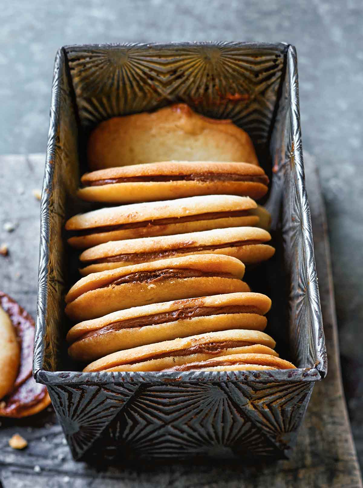 Eight homemade Milano cookies in a metal loaf tin.
