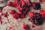 Chunks of roasted strawberries on a sheet of parchment.