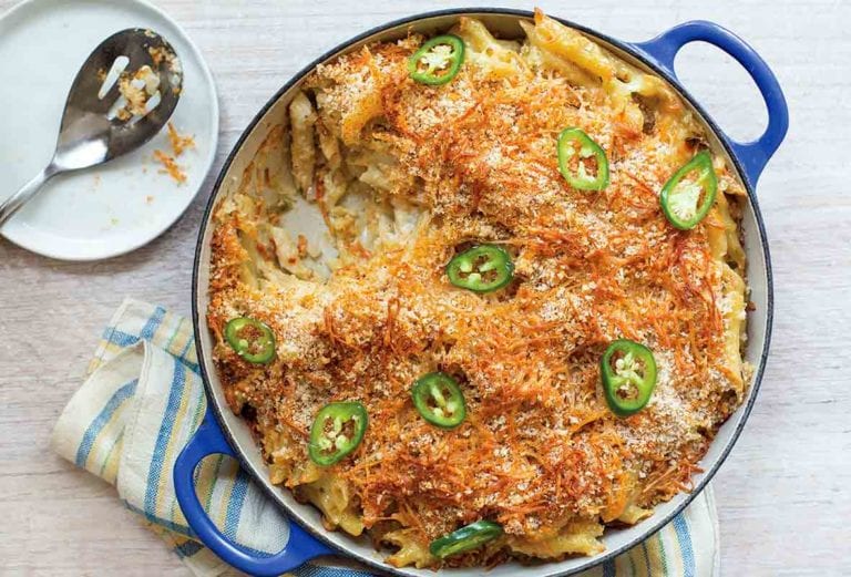 Blue casserole of spicy macaroni and cheese with breadcrumbs on top and sliced of jalapeno peppers