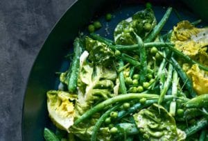 A black bowl fill with green beans, peas, and lettuce tossed with buttermilk ranch dressing