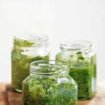 Three glass jars partially filled with pesto Genovese.