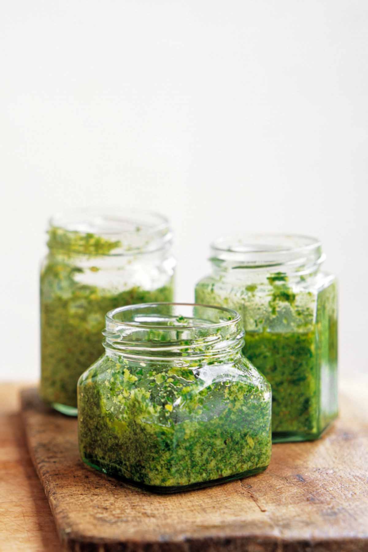 Three glass jars partially filled with pesto Genovese.