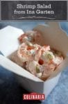 A white takeout container filled with shrimp salad by Ina Garten--shrimp, mayonnaise, dill, red onion, celery, and lemon zest