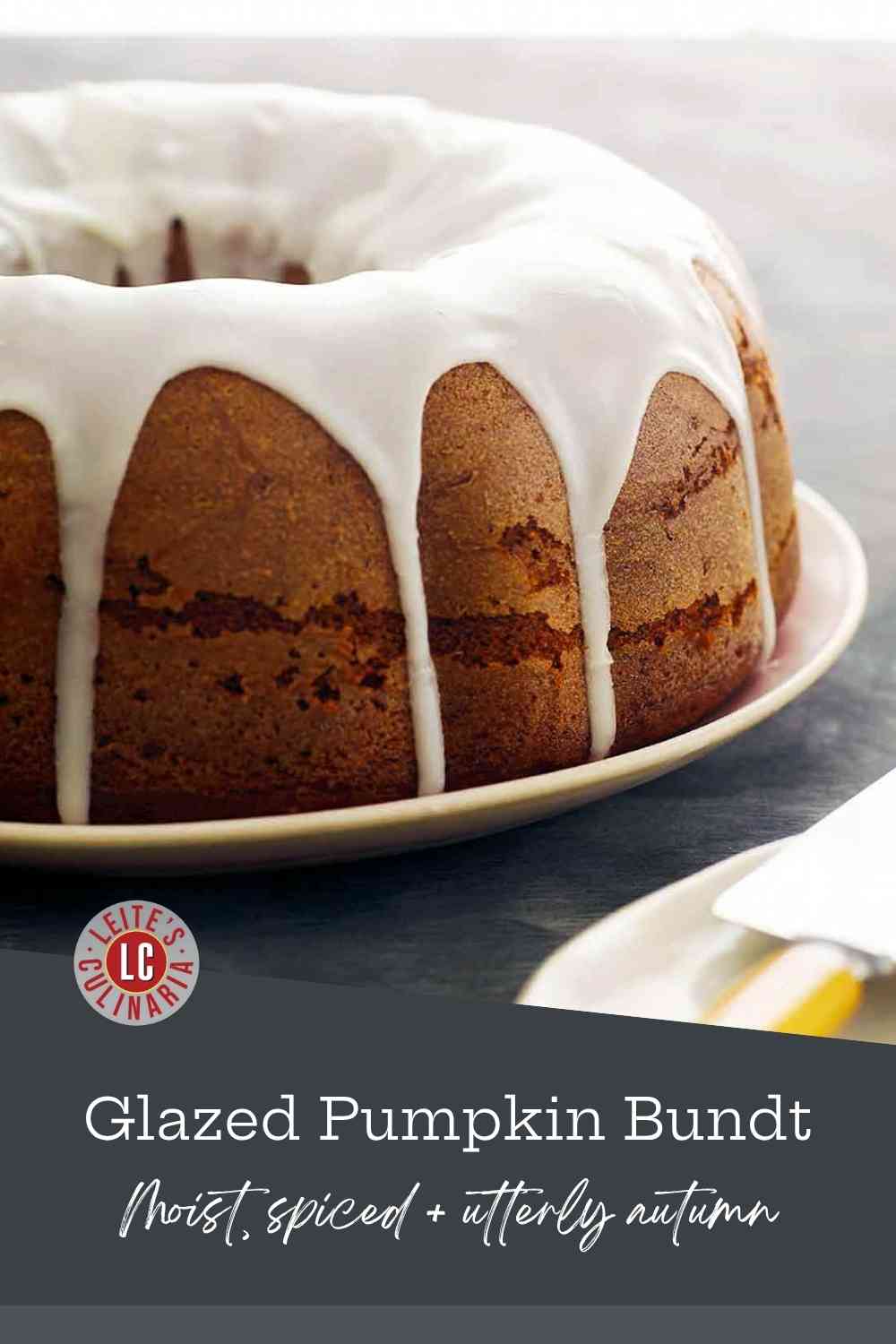 Close-up of a warm-toned pumpkin spice Bundt cake with a thick, white vanilla glaze generously dripping down the sides.