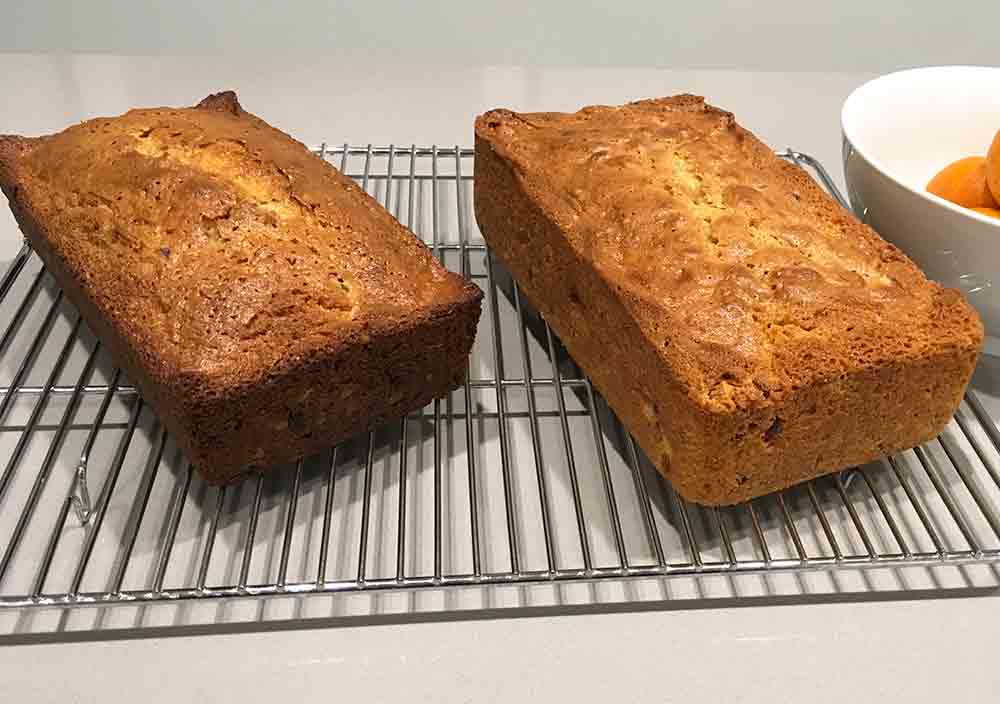 Two loaves of cranberry orange pecan bread cooling on a wire rack