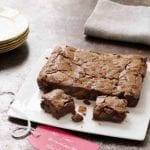 A square white platter with fruitcake brownies--filled with dried fruit, chocolate, and rum.