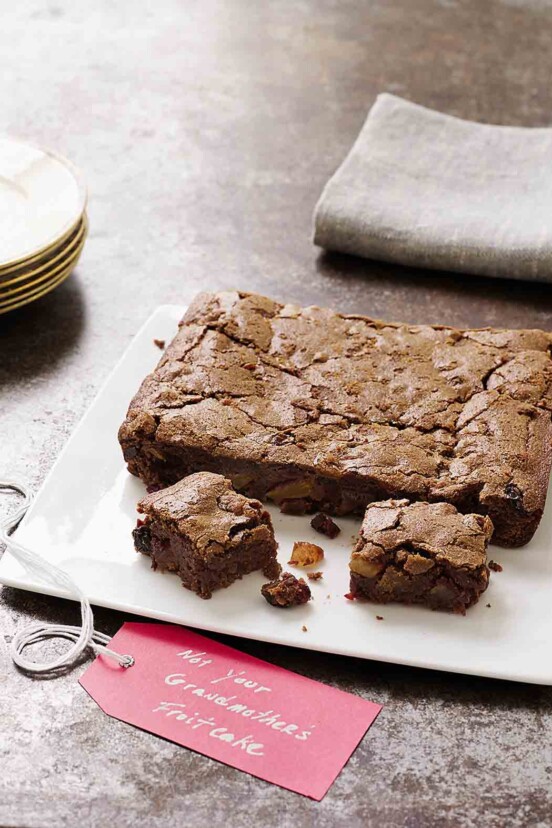 A square white platter with fruitcake brownies--filled with dried fruit, chocolate, and rum.