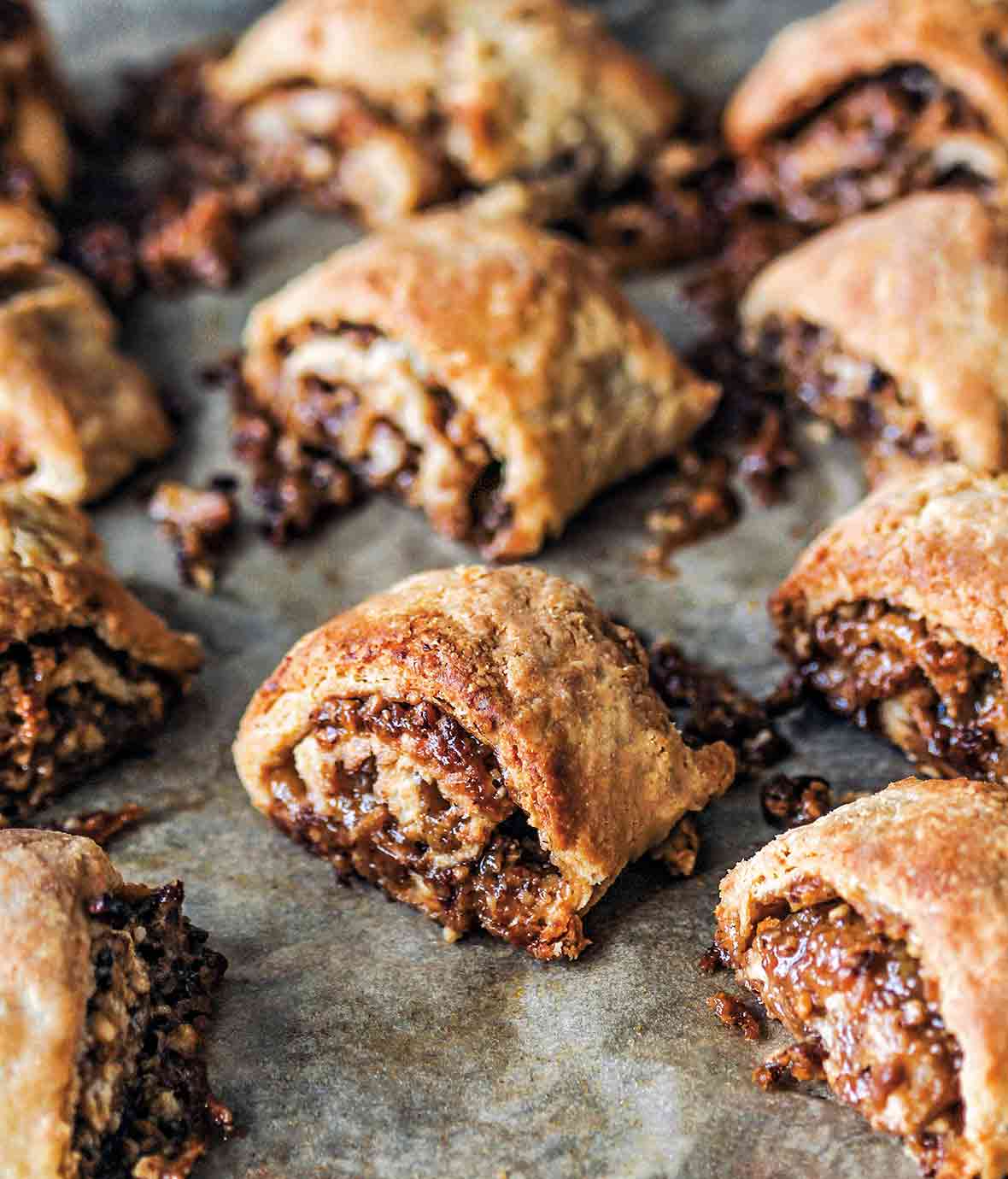 A dozen golden brown pecan pie rugelach with the filling oozing out