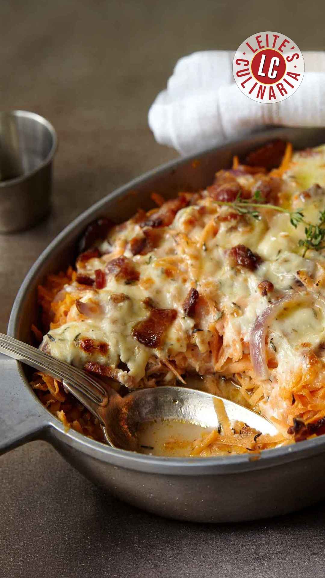 A chicken, sweet potato, and bacon casserole in an oval dish, topped with melted cheese.