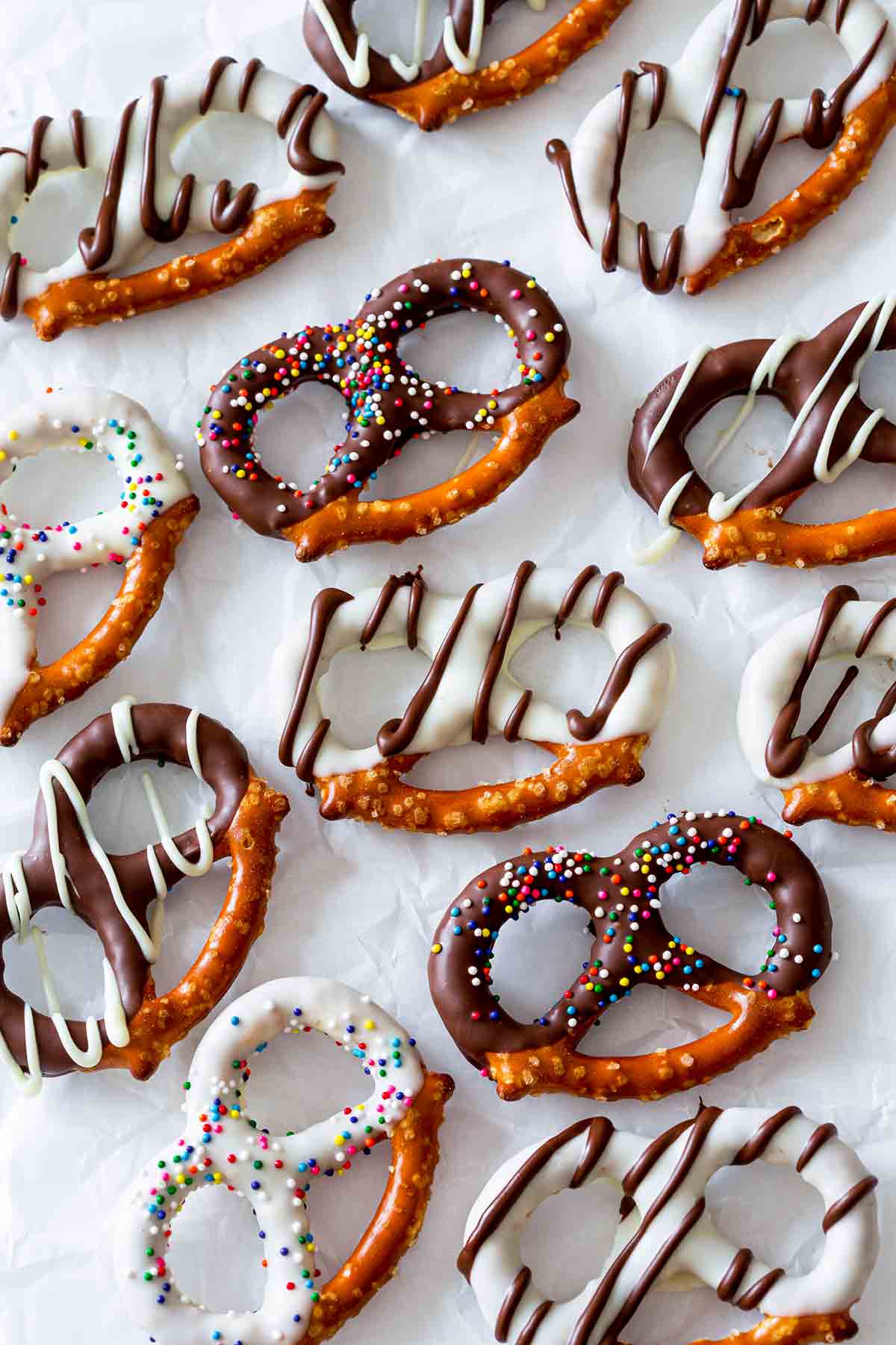 An assortment of chocolate covered pretzels with white and dark chocolate coating and sprinkles