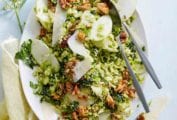 A kale and Brussels Sprouts Salad tossed with a honey-mustard dressing and topped with parmesan cheese and sweet-spicy nuts