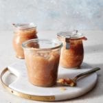 Three jars of slow cooker apple pear sauce on a white tray