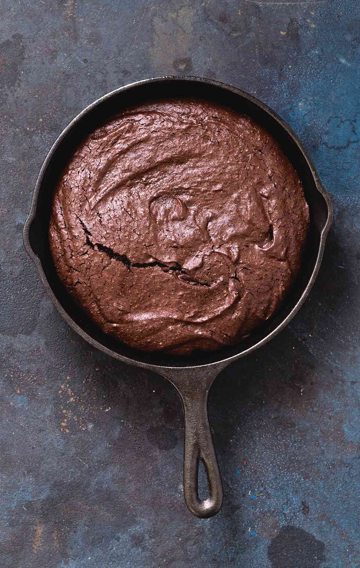 A cast-iron skillet filled with chocolate brownie.