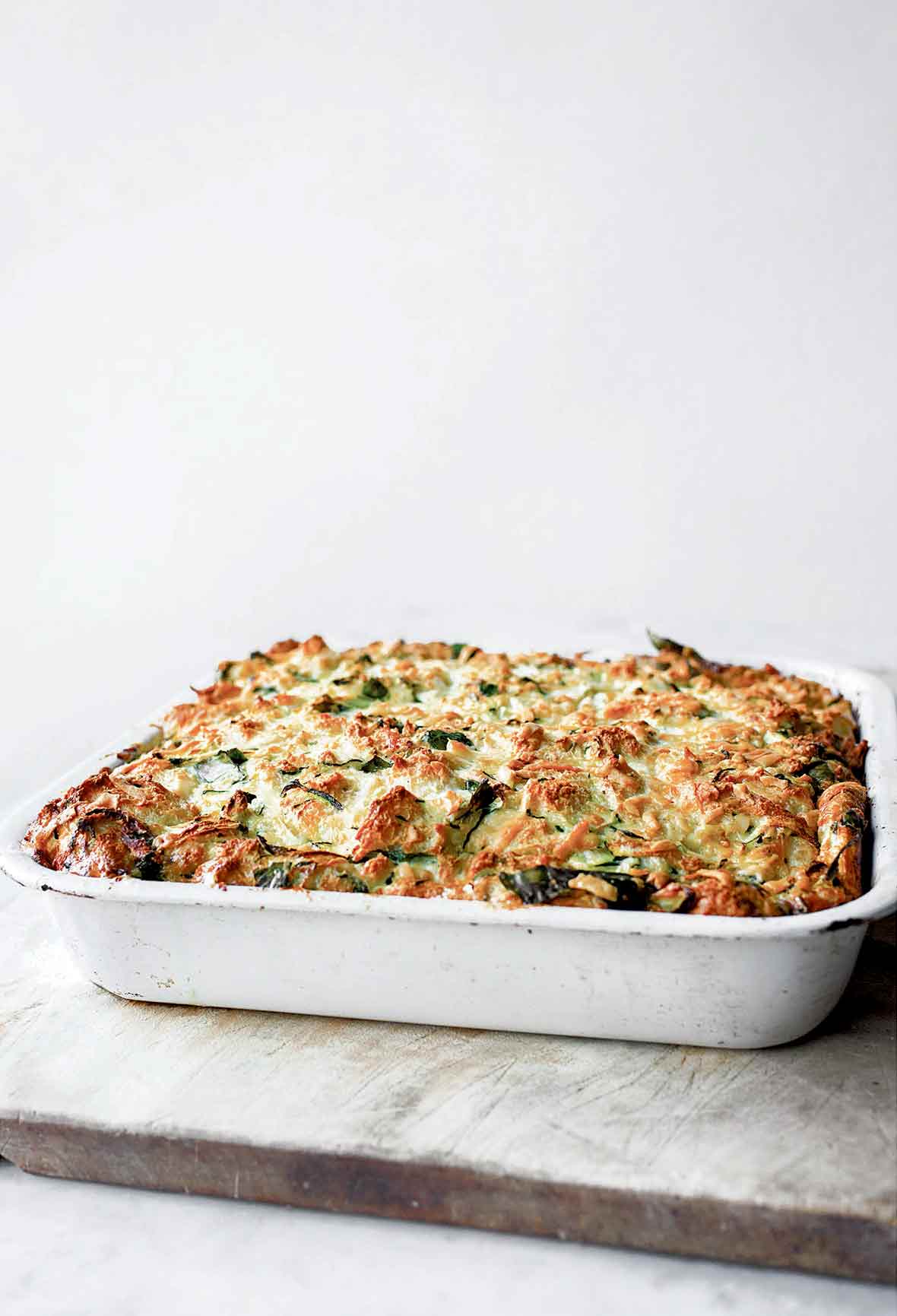 A white baking dish filled with zucchini strata