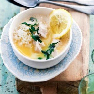 A white and blue bowl filled with healthy avgolemono made with fish, rice, and lemon