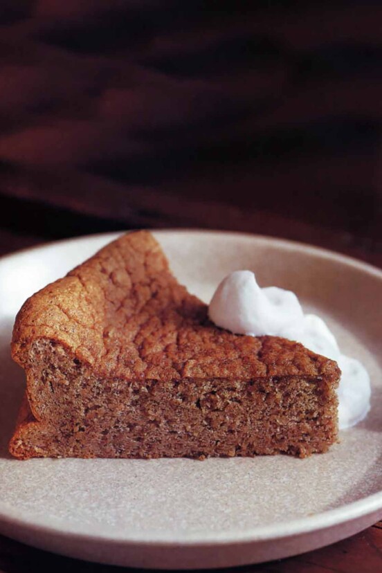 A slice of pecan torte with bourbon whipped cream dolloped on the side