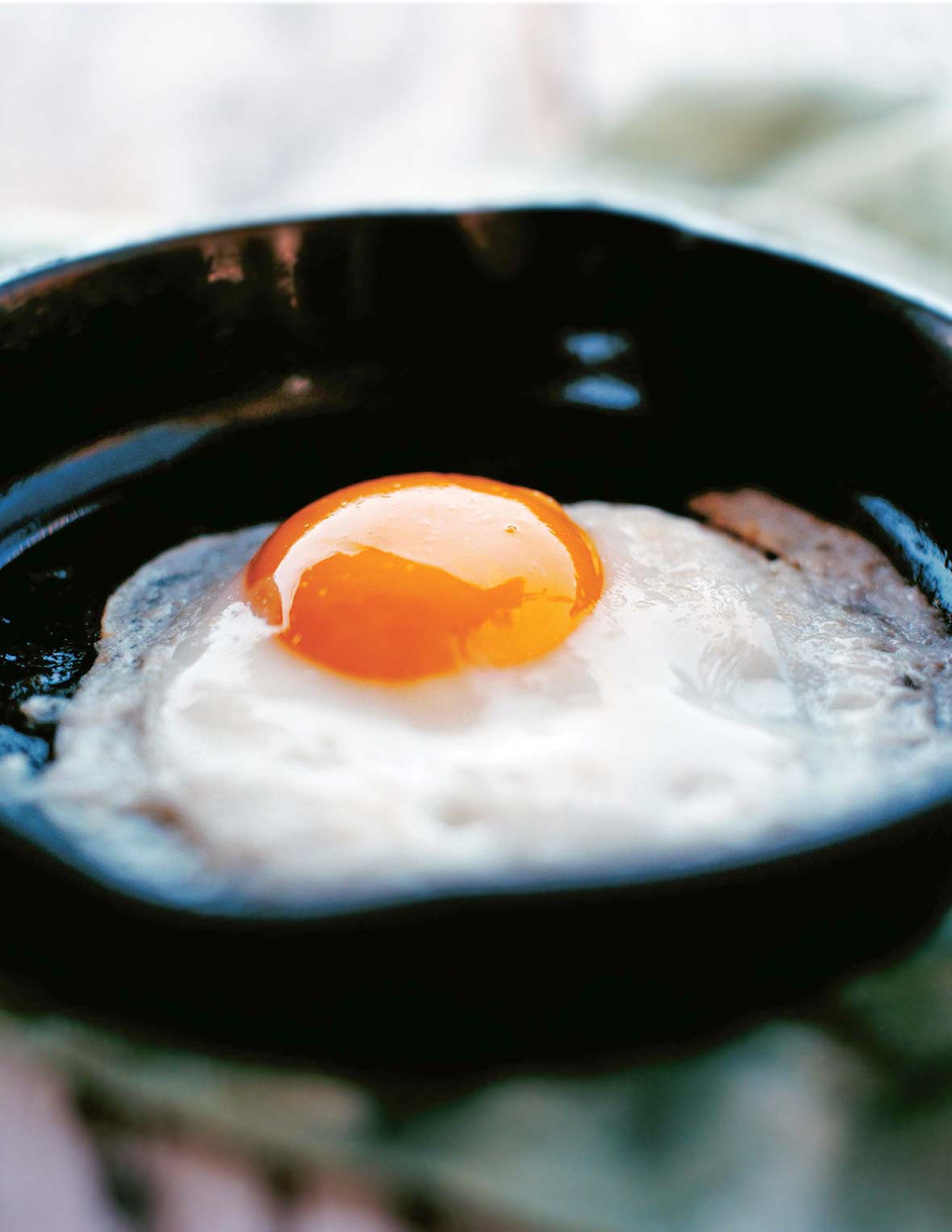 A perfect fried egg in a small black skillet.