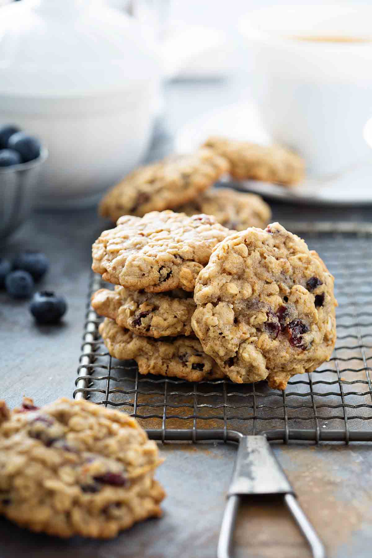 A stack of several oatmeal raisin cookies on a wire paddle.