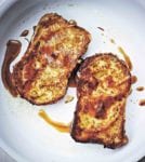 Two slices of French toast, fried until golden and drizzled with maple syrup.