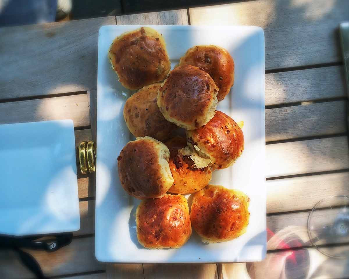 Portuguese presunto and cheese loaves on a white platter.